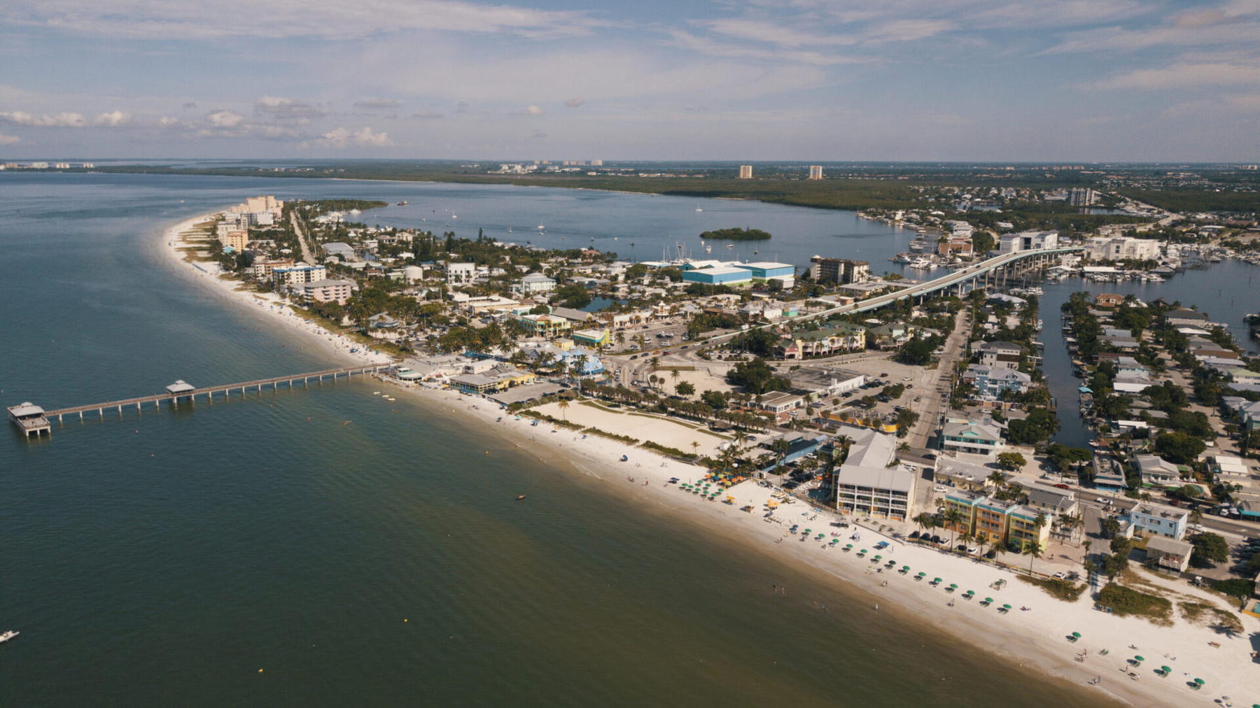 Aerial view of Fort Myers Beach, with the fishing pier, the white sand shoreline and the Gulf of Mexico.